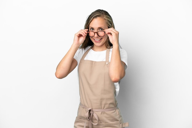 Restaurant waiter caucasian woman isolated on white background with glasses and surprised