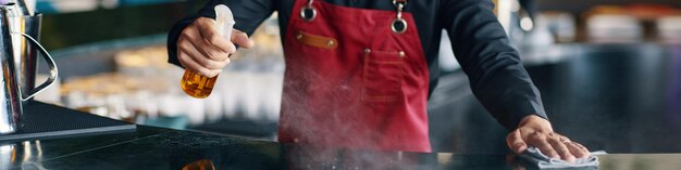 Restaurant waiter cleaning bar counter