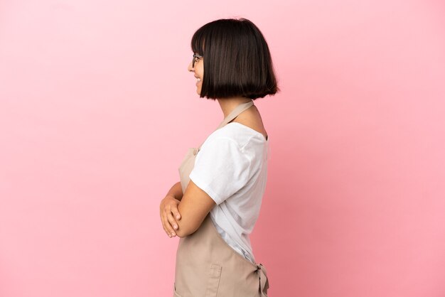 Restaurant waiter over isolated pink background in lateral position