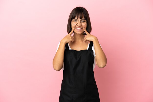 Restaurant waiter over isolated pink background smiling with a happy and pleasant expression