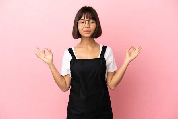 Restaurant waiter over isolated pink background in zen pose