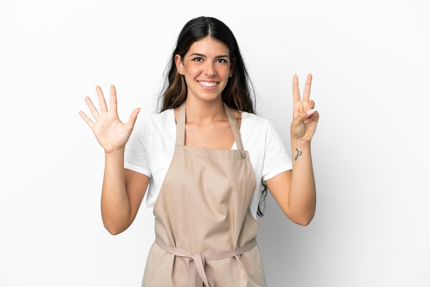 Restaurant waiter over isolated white background counting seven with fingers