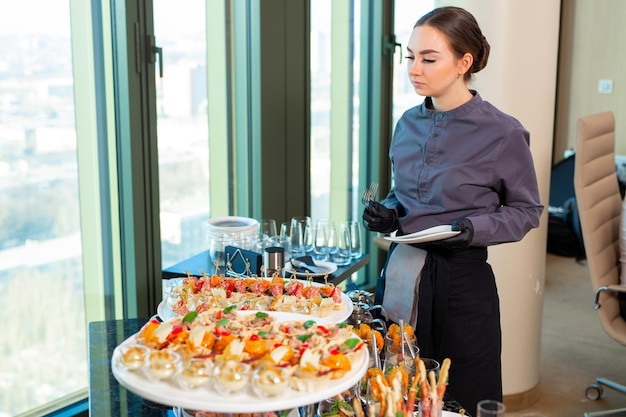 Foto un cameriere del ristorante serve un banchetto fuori sede nell'officexa