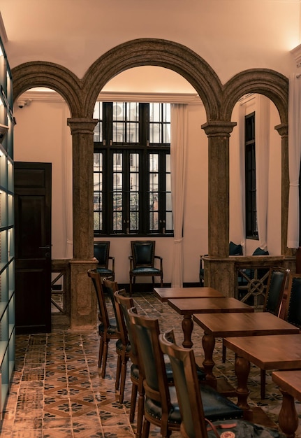 A restaurant with a large arch and a table with chairs and a table with chairs.