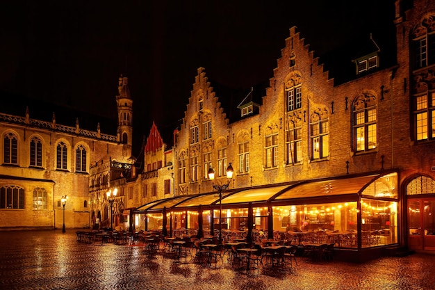 Restaurant with a terrace in the old Europe town square on a rainy night