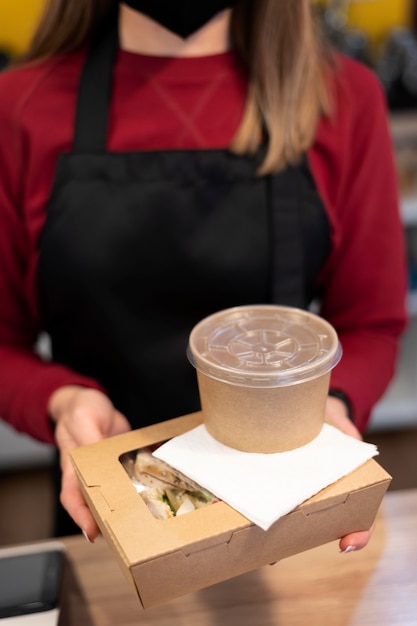 Restaurant worker handing the order to a client