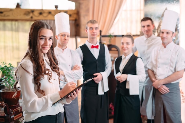 Restaurantmanager en zijn personeel in keuken. interactie met chef-kok in commerciële keuken.