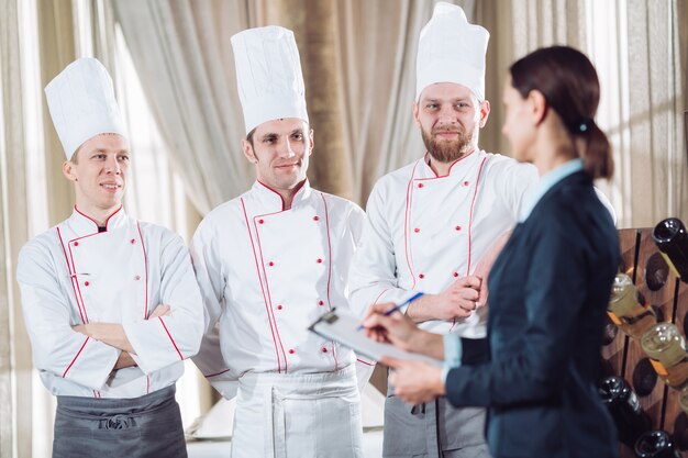 Restaurantmanager en zijn personeel in keuken.