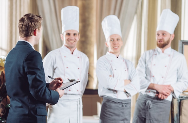 Restaurantmanager en zijn personeel in keuken.