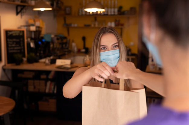 Restaurantmedewerker die de bestelling overhandigt aan een klant