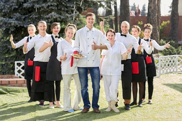 Restaurantpersoneel dat samen staat en hun duimen laat zien