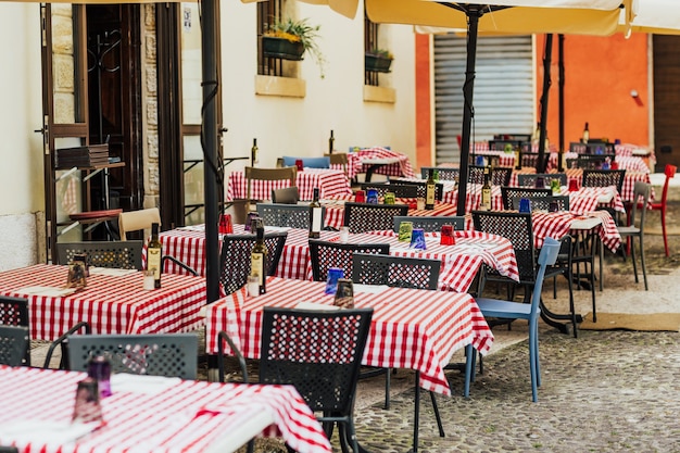 Restauranttafels en stoelen op een klein plein in italië.