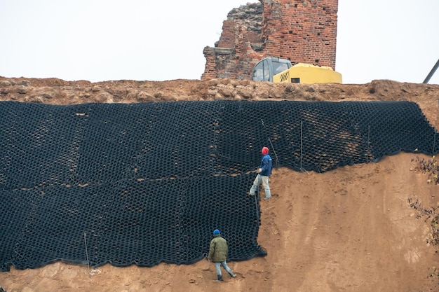 Restauratie van het Novogrudok-kasteel in Novogrudok Builders en een graafmachine op een bouwplaats in de buurt van een historisch gebouw