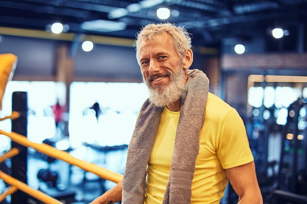 Resting after boxing training portrait of a positive handsome mature man in sportswear looking at