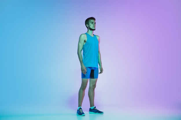 Resting Portrait of young caucasian man running jogging on gradient studio background