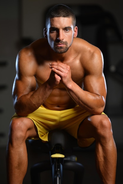 Resting Time  Confident Muscled Young Man Resting In Healthy Club Gym After Exercising