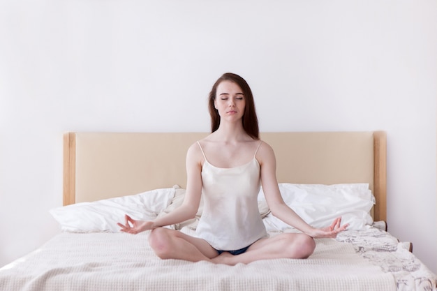 Resting yoga girl on bed concept. Harmony comfort morning at home. Self-confidence and calmness