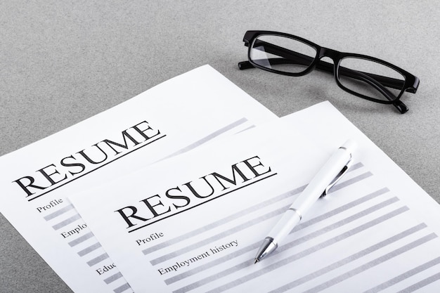 Photo resume pen and glasses on the table closeup recruitment concept