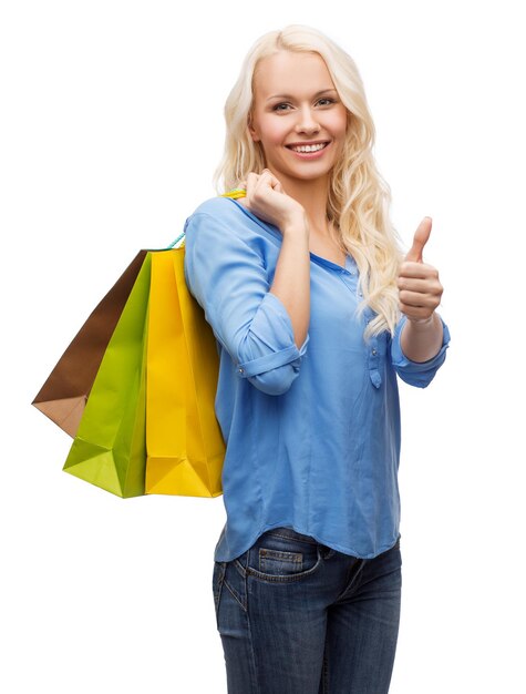 retail, gesture and sale concept - smiling woman with many shopping bags showing thumbs up