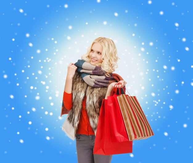 retail and sale concept - happy teenage girl in winter clothes with shopping bags