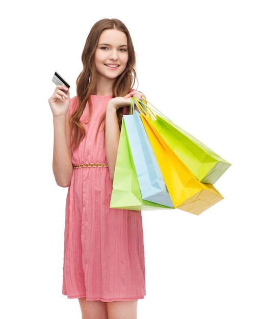 retail and sale concept - smiling woman in dress with many shopping bags and credit card