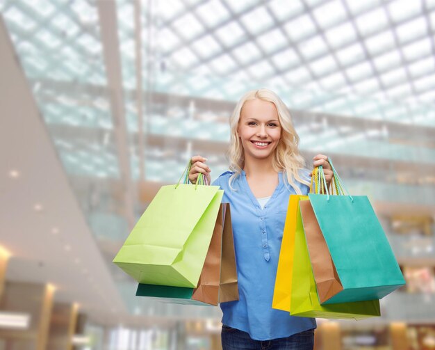 retail and sale concept - smiling woman with many shopping bags