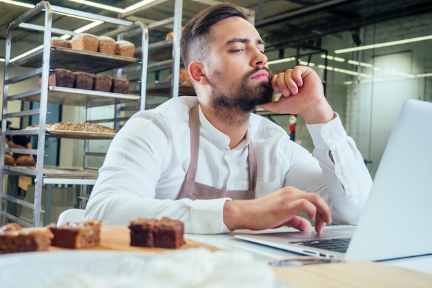 Retailhandel concept man eigenaar van voedselfabriek met behulp van apparaten voor online zakelijke bestelling bij bakkerij