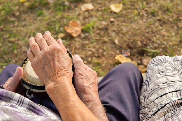 Пара на пенсии играет на джембе Музыкальная терапия со стариками