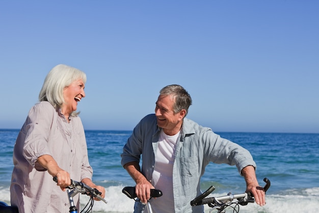 Retired couple with their bikes on the beach