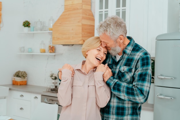 Retired husband and wife hug each other at home