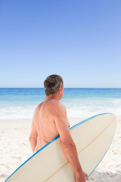 Retired man with his surfboard