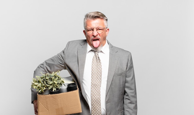 Photo retired senior businessman feeling disgusted and irritated, sticking tongue out, disliking something nasty and yucky