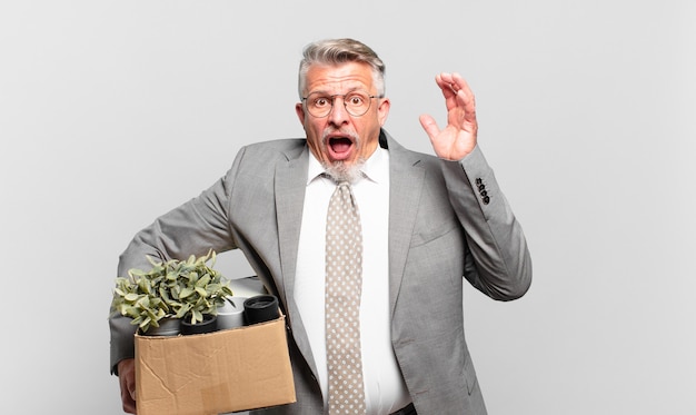 Photo retired senior businessman screaming with hands up in the air, feeling furious, frustrated, stressed and upset