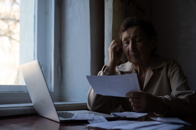 Retired woman calculating her domestic bills