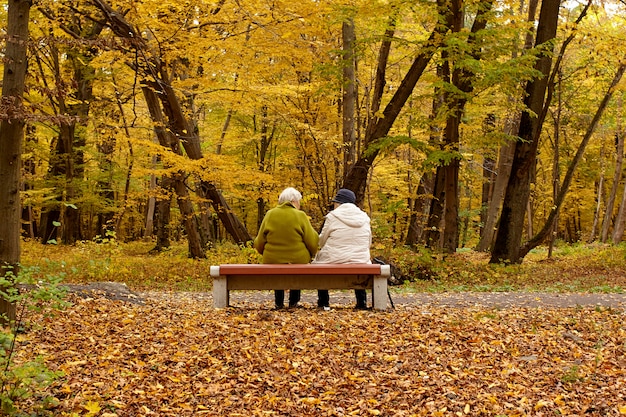 Retirees. Elderly women rest on a bench in a park.