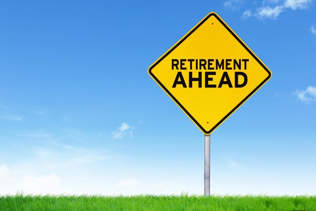 Retirement ahead road sign against empty field and blue sky