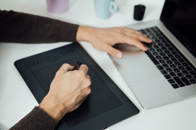 Retoucheren op computerlaptop met digitale tablet en styluspen