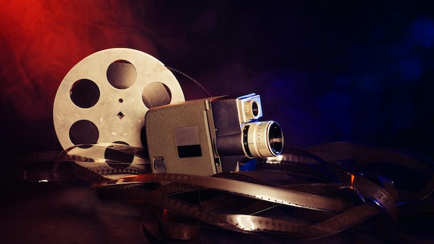 Retro 8 mm movie camera with a reel of film in smoke