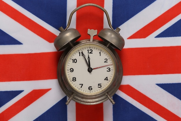 Retro alarm clock on background of Great Britain flag