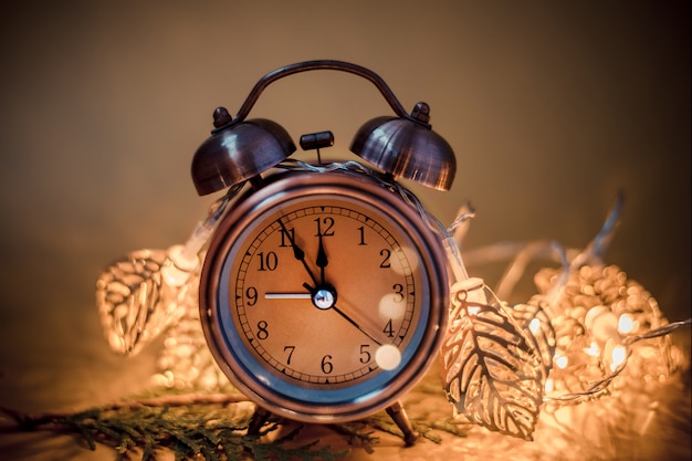 Retro alarm clock on blurred christmas decoration