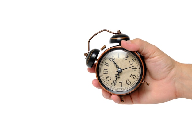 Retro alarm clock in hand on a white background