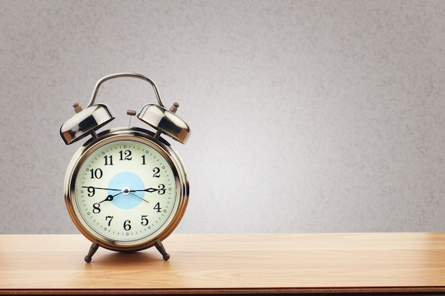 Retro alarm clock on wooden table with purple wall background