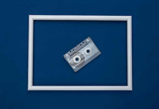 사진 흰색 프레임이 있는 고전적인 파란색 배경의 복고풍 오디오 카세트. 컬러 2020. 탑 뷰