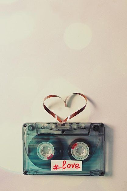 Ретро аудиокассета с лентой в форме сердца на белом фоне