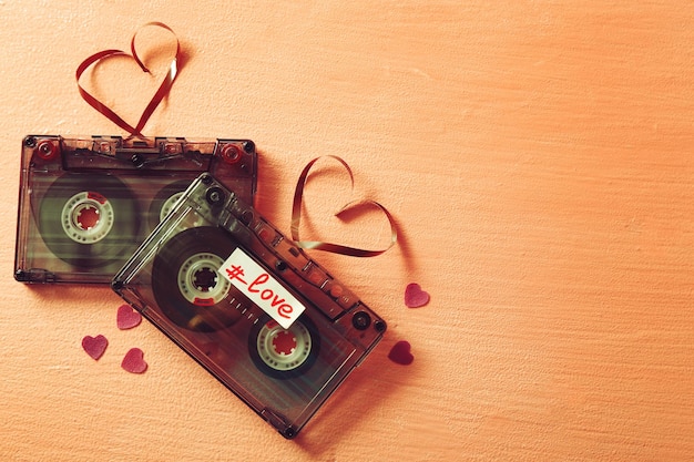Фото Ретро аудиокассеты с лентами в форме сердец на розовом текстурированном фоне