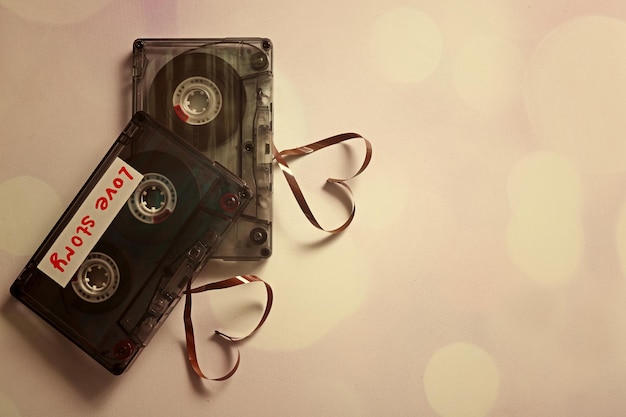 Photo retro audio cassettes with tapes in shape of hearts on white background