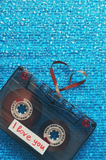 Foto retro audiocassette met tape in de vorm van een hart op blauwe gestructureerde achtergrond