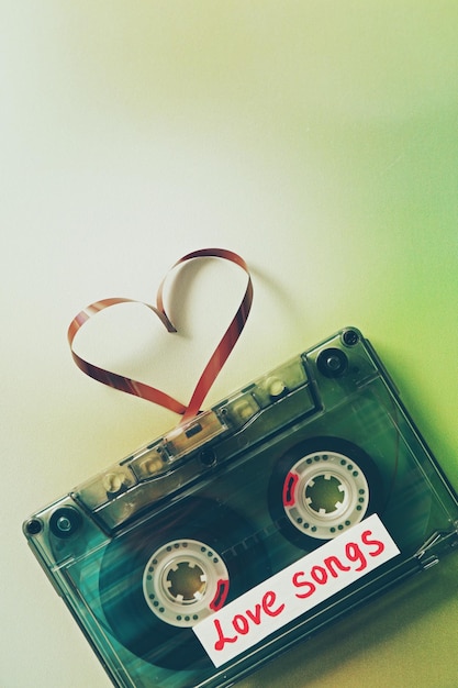 Retro audiocassette met tape in de vorm van een hart op groene onscherpe achtergrond