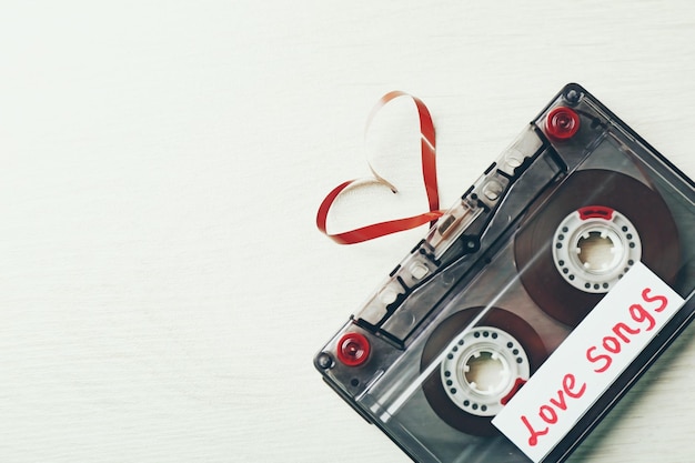 Retro audiocassette met tape in de vorm van een hart op houten achtergrond