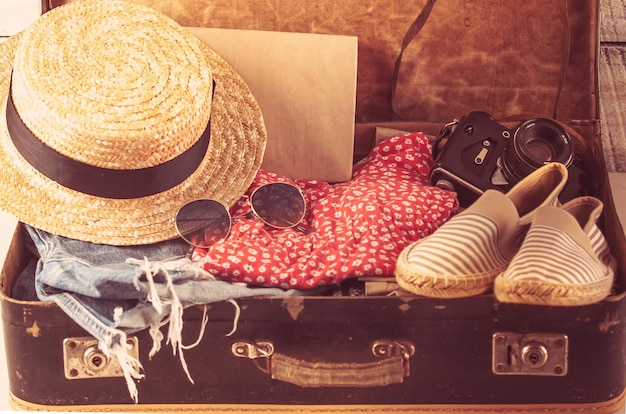 Retro bag for summer vocation with photo camera book and wicker\
hat